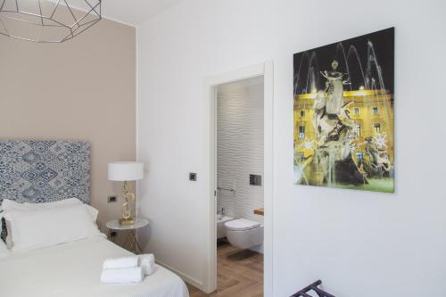 a white bedroom with a bed and a bathroom at AmaSi Affittacamere in Siracusa