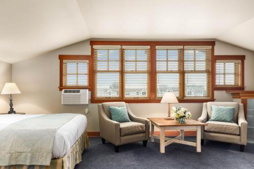 a bedroom with a bed and two chairs and a table at La Conner Channel Lodge in La Conner