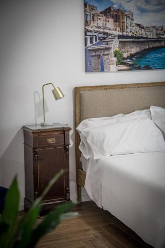 a bedroom with a bed and a lamp on a nightstand at AmaSi Affittacamere in Siracusa