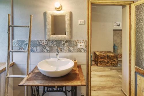 Happy hill - appartamento Bambù-natura e relax في Santa Maria Rocca: حمام مع حوض أبيض على منضدة خشبية