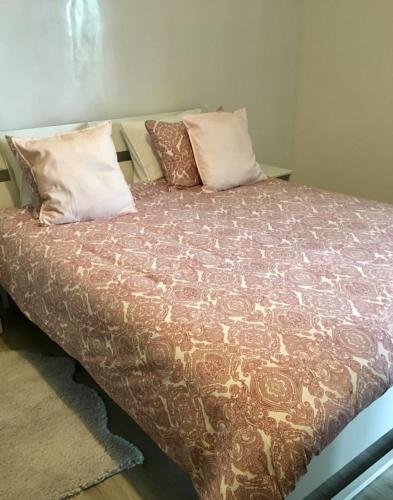 a bed with pillows on it in a room at Appartement Miramar in Mohammedia