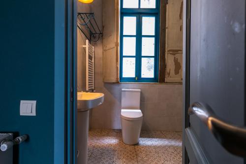 a bathroom with a toilet and a sink and a window at 3 Heritage Rooms in Tbilisi City