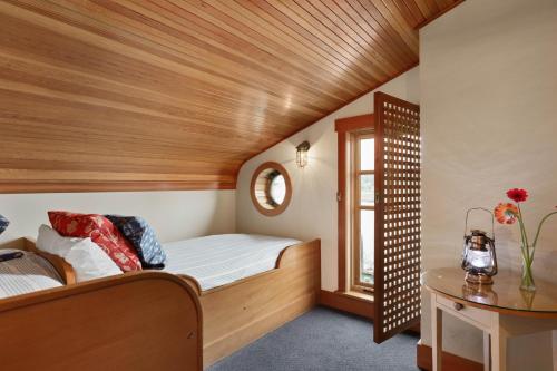 a small attic bedroom with a bed and a window at La Conner Channel Lodge in La Conner