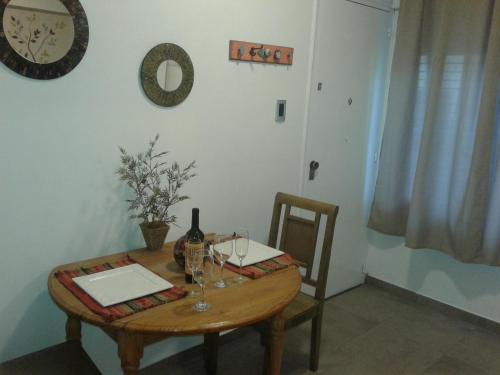 una mesa con una botella de vino y copas. en IDEAL Y UBICADISIMO A Mts de paseo ARISTIDES . en Mendoza