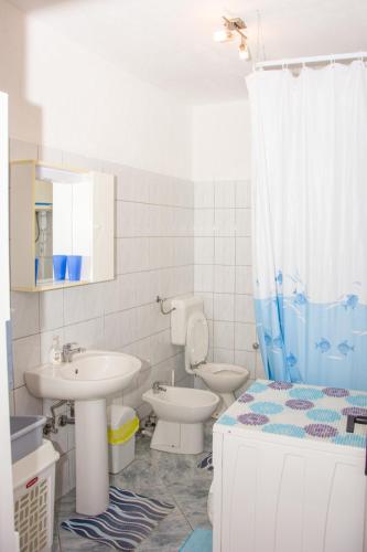 a bathroom with a sink and a toilet and a shower at Apartman GROMILA in Senj