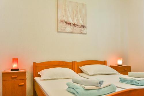 two twin beds in a room with two candles at Apartman GROMILA in Senj