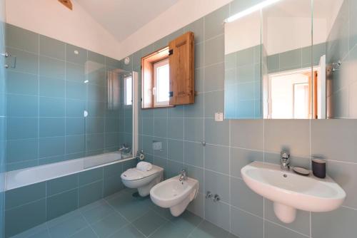 a bathroom with two sinks and a toilet and a mirror at Cardosas Palace Apartment in Porto