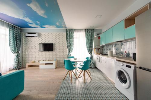 ママイアにあるSummerland Sunrise Apartmentsのキッチン(洗濯機、テーブル、椅子付)