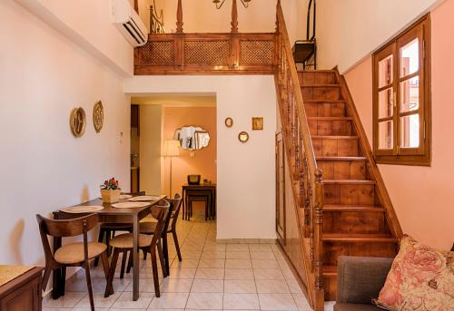 a dining room with a table and a staircase at The Old Symi in Symi