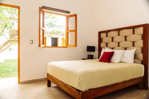 Un dormitorio con una cama grande y una ventana en Kinta Kan Hotel Boutique Cozumel, en Cozumel