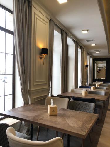 a row of tables and chairs in a room with windows at Jermuk Hotel and SPA in Jermuk