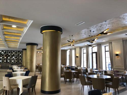 a dining room with tables and chairs and windows at Jermuk Hotel and SPA in Jermuk