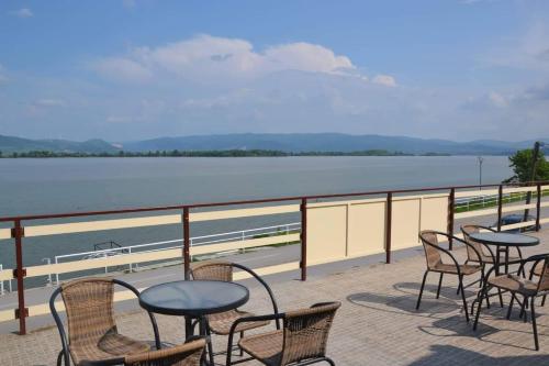 a balcony with tables and chairs and a view of the water at Guest House Bole in Vinci