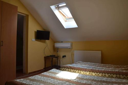 a small bedroom with two beds and a skylight at Guest House Bole in Vinci