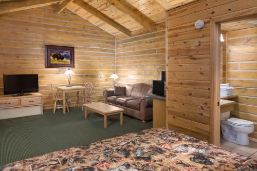 a bedroom with a bed and a couch and a table at Rock Crest Lodge & Cabins in Custer