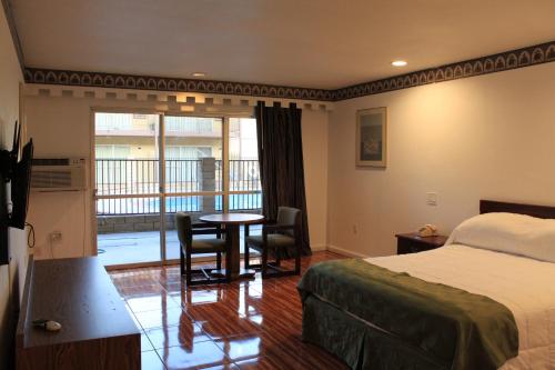 Habitación de hotel con cama, mesa y sillas en Menifee Inn, en Menifee