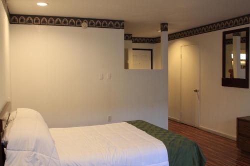 a bedroom with a white bed and a mirror at Menifee Inn in Menifee