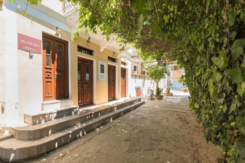 an empty street with a building with wooden doors at The Old Symi in Symi