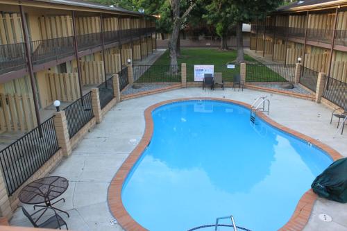 a large swimming pool at a hotel with tables and chairs at Menifee Inn in Menifee