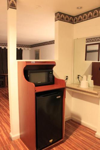 a hotel room with a microwave and a kitchen at Menifee Inn in Menifee