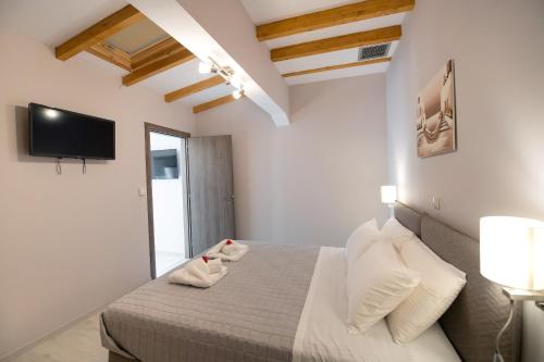 a bedroom with a bed and a tv on the wall at Casa Demi in Vasiliki