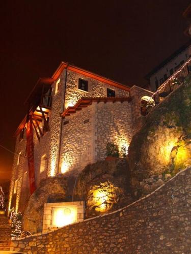 a building on top of a hill at night at Archontiko Deligianni in Dhimitsana