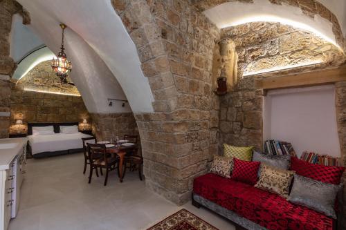 a living room with a red couch and a stone wall at Alma in ‘Akko