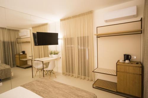 a room with a bedroom with a bed and a desk at Hedoné Design Experience B&B in Agrigento
