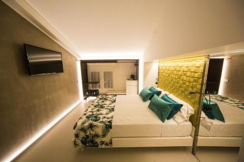 a hotel room with a bed with green pillows at Hedoné Design Experience B&B in Agrigento