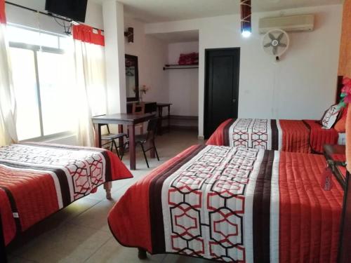 a room with two beds and a table with a dining room at Kali Huasteca Posada in Ciudad Valles