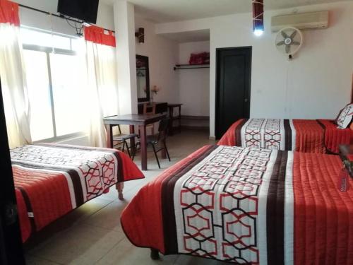 a hotel room with two beds and a table with a table at Kali Huasteca Posada in Ciudad Valles