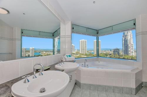 a bathroom with two sinks and a tub and a window at The Waterford on Main Beach in Gold Coast