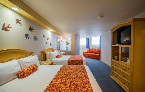 a hotel room with two beds and a couch at Aranzazu Plaza Kristal Aguascalientes in Aguascalientes