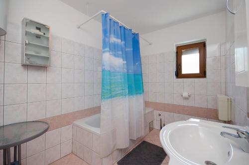 a bathroom with a sink and a tub and a toilet at Apartments Marta in Sveti Juraj