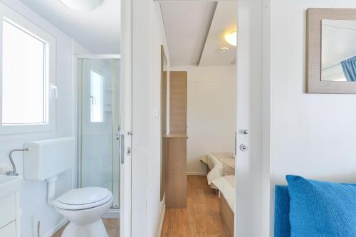 a small bathroom with a toilet and a staircase at Mobile house Nord 2 Laguna in Turanj
