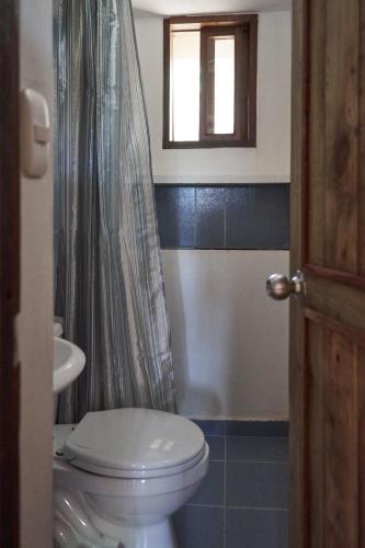 a bathroom with a toilet and a shower curtain at Casa Caracola in Tubará