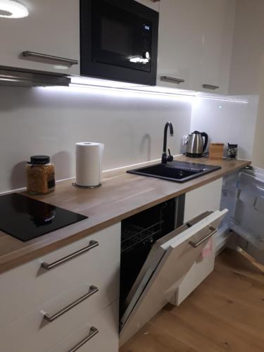 a kitchen with a sink and a stove top oven at Apartament Reda z prywatną sauną lub antresolą in Reda