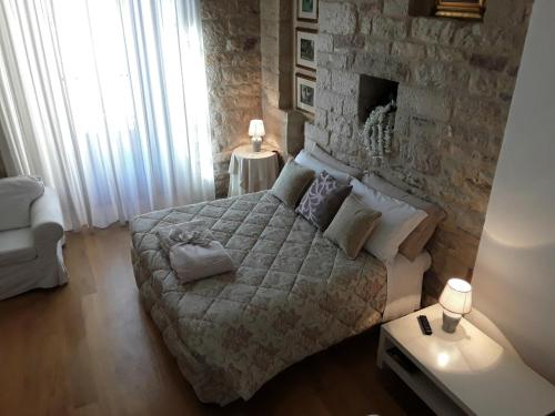 a bedroom with a large bed and a stone wall at Case Brizi 10 in Assisi