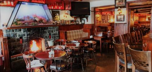 a restaurant with tables and chairs and a large screen at Danagher’s Hotel Cong in Cong