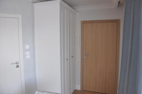 pasillo con puerta y puerta de madera en Apartament Bello Mechelinki en Mechelinki