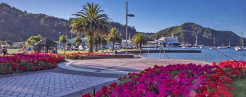 a bunch of flowers in a park next to a body of water at 3 & 4 Bedroom Holiday Houses Central Picton in Picton