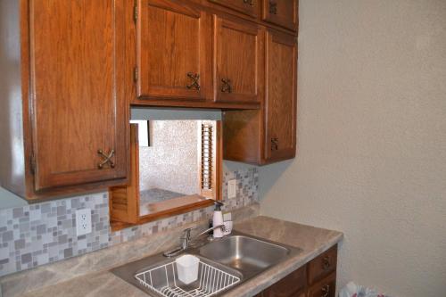 a kitchen with a sink and wooden cabinets at Perfect Place in Grand Forks