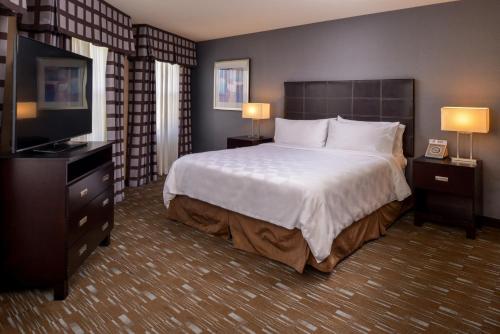 a hotel room with a bed and a flat screen tv at Holiday Inn Ontario Airport - California, an IHG Hotel in Ontario