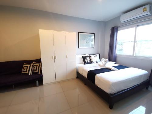 ein Schlafzimmer mit einem Bett und einem Sofa in der Unterkunft ibeyond Apartment Romklao Suvarnabhumi in Lat Krabang