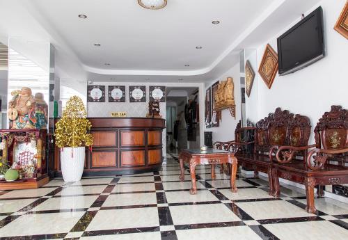 uma sala de estar com mobiliário em madeira e uma árvore de Natal em Song Hung Hotel em Cà Mau