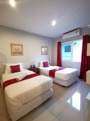 a bedroom with two beds and a window at ibeyond Apartment Romklao Suvarnabhumi in Lat Krabang