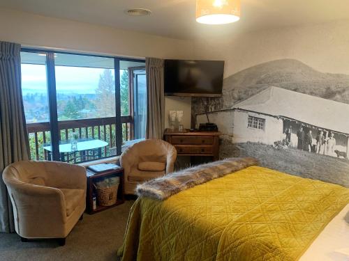 a bedroom with a bed and a balcony at 8 on Oregon Boutique Lodge in Hanmer Springs