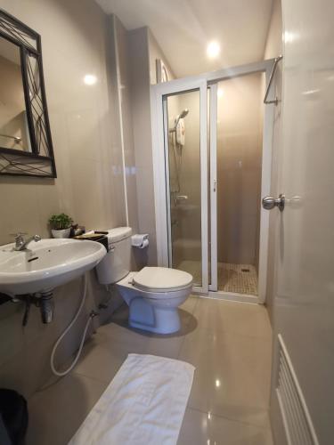 a bathroom with a toilet and a sink and a shower at ibeyond Apartment Romklao Suvarnabhumi in Lat Krabang