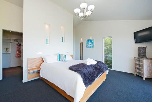 um quarto com uma cama grande e uma televisão em Selah Retreat em Nelson