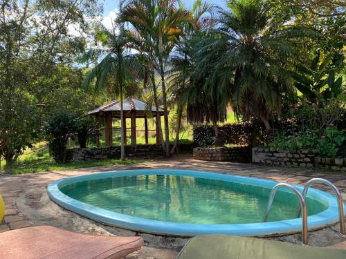 a swimming pool in a yard with a gazebo at Casa na serra com cachoeira in Bom Jardim